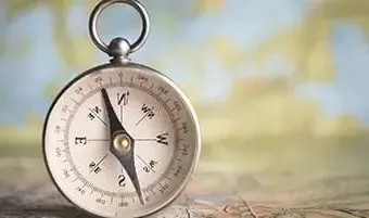 compass standing upright on a wood table